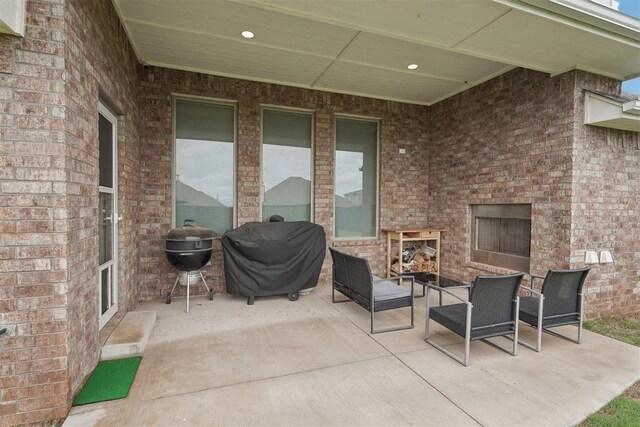 view of patio / terrace with exterior fireplace and a grill