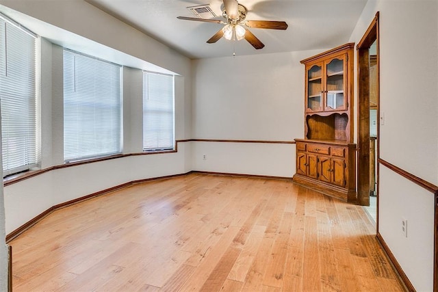 10601 Songbird Ln, Oklahoma City, OK 73130 - spare room featuring a ceiling fan, baseboards, visible vents, and light wood-type flooring