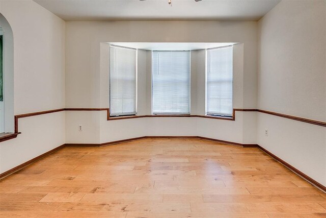 10601 Songbird Ln, Oklahoma City, OK 73130 - unfurnished room featuring arched walkways, baseboards, and light wood finished floors