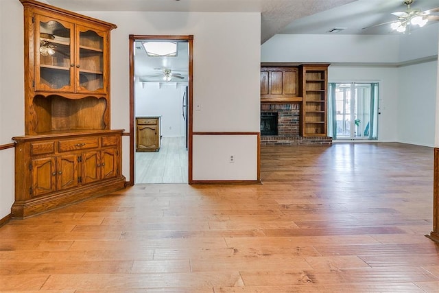 10601 Songbird Ln, Oklahoma City, OK 73130 - unfurnished living room with light wood-style floors, baseboards, ceiling fan, and a fireplace