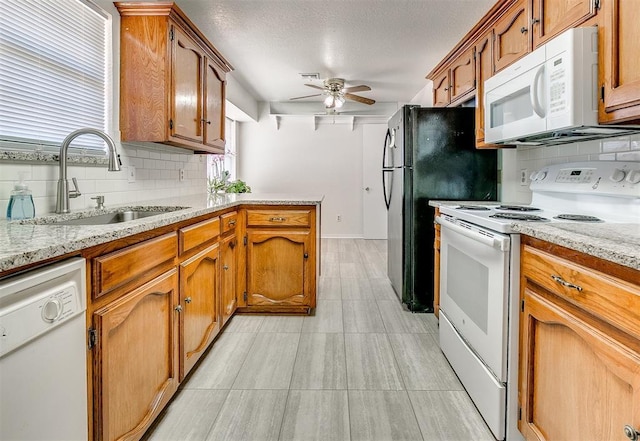 10601 Songbird Ln, Oklahoma City, OK 73130 - kitchen with ceiling fan, brown cabinetry, backsplash, a sink, and white appliances