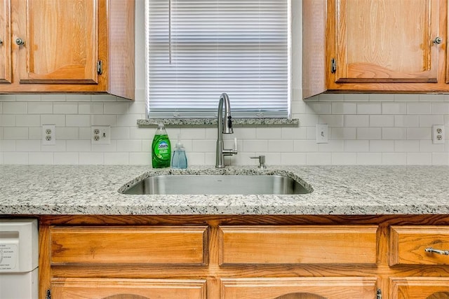 10601 Songbird Ln, Oklahoma City, OK 73130 - kitchen featuring brown cabinetry, a sink, and backsplash