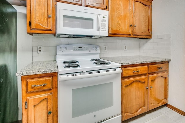 10601 Songbird Ln, Oklahoma City, OK 73130 - kitchen featuring brown cabinets, white appliances, baseboards, decorative backsplash, and light tile patterned floors