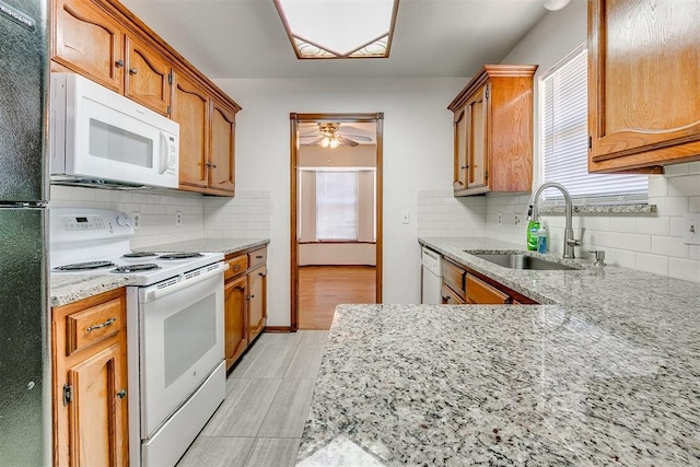 10601 Songbird Ln, Oklahoma City, OK 73130 - kitchen with white appliances, light stone countertops, ceiling fan, a sink, and backsplash