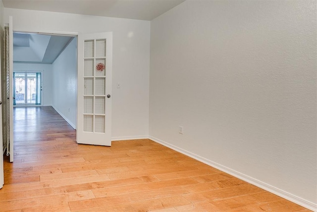10601 Songbird Ln, Oklahoma City, OK 73130 - empty room featuring baseboards, french doors, lofted ceiling, and light wood-style floors