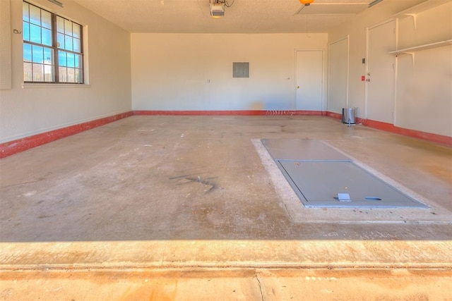 10601 Songbird Ln, Oklahoma City, OK 73130 - garage featuring baseboards, a garage door opener, and electric panel