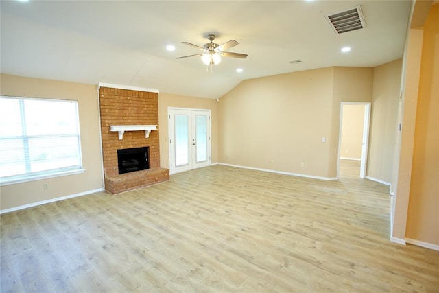 unfurnished living room with a brick fireplace, a ceiling fan, baseboards, light wood-type flooring, and visible vents