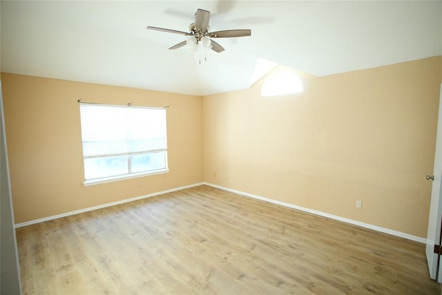 spare room with wood finished floors, a ceiling fan, and lofted ceiling