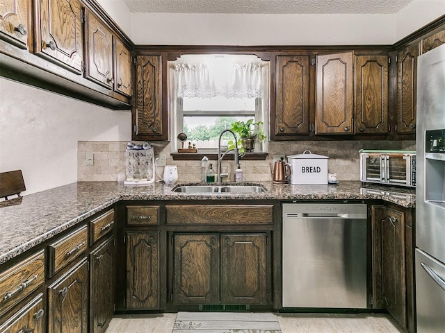 kitchen with a toaster, dark brown cabinets, a sink, backsplash, and stainless steel appliances
