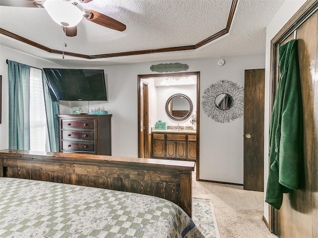 carpeted bedroom featuring a sink, a ceiling fan, ensuite bath, and a textured ceiling