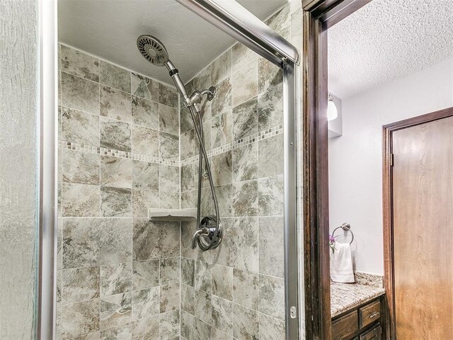 full bathroom featuring a stall shower and a textured ceiling