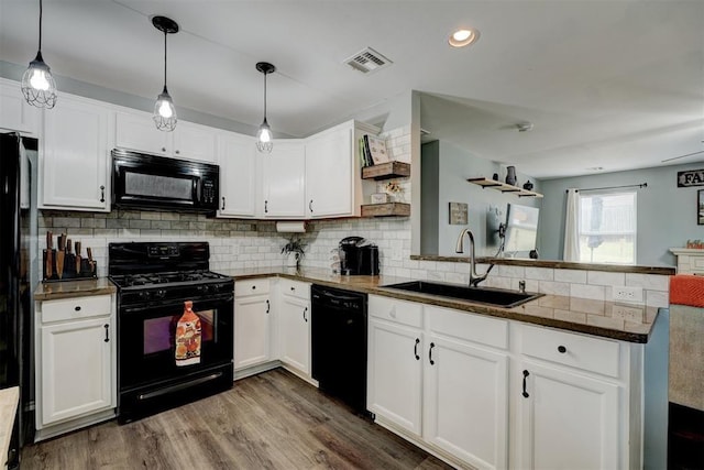 kitchen featuring open shelves, a sink, a peninsula, visible vents, and black appliances
