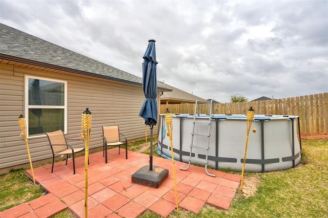 view of patio featuring fence and an outdoor pool