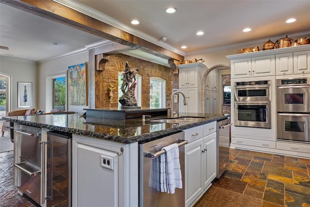 2203 E Wilshire Blvd, Oklahoma City, OK 73111 - kitchen featuring a sink, stainless steel appliances, wine cooler, crown molding, and an island with sink