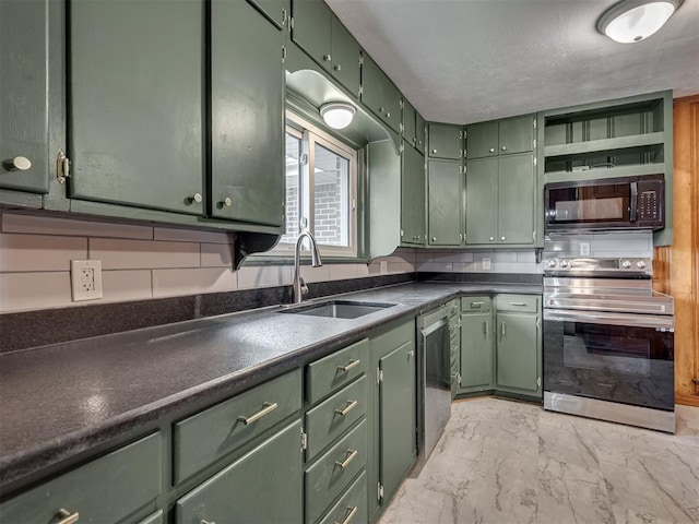 kitchen featuring marble finish floor, dark countertops, green cabinetry, a sink, and stainless steel appliances