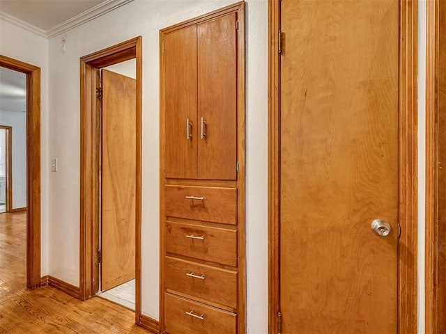 interior space with crown molding, baseboards, and wood finished floors