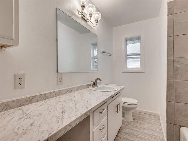 full bathroom with vanity, baseboards, toilet, and wood finished floors
