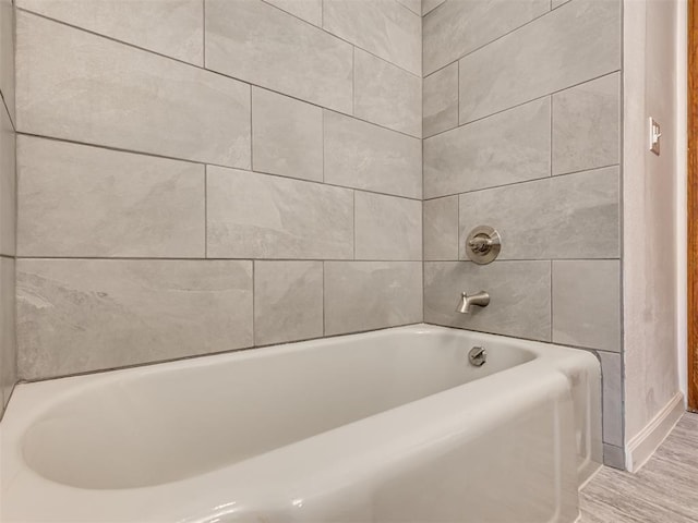 bathroom featuring a tub and baseboards