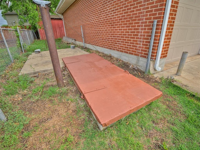 details featuring fence and brick siding