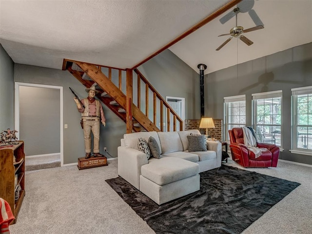 carpeted living room featuring stairs, baseboards, high vaulted ceiling, a textured ceiling, and a ceiling fan