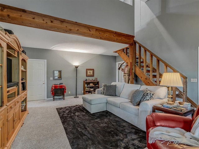 carpeted living room with stairway, baseboards, and beamed ceiling