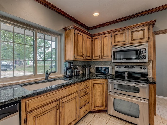 kitchen featuring a sink, appliances with stainless steel finishes, crown molding, and light tile patterned flooring