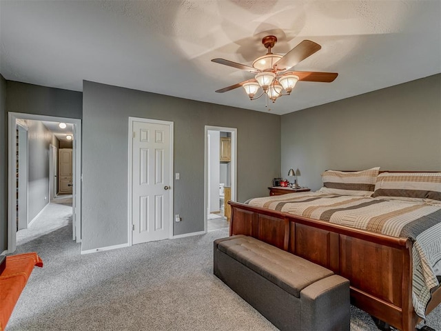 carpeted bedroom featuring baseboards, a ceiling fan, and connected bathroom