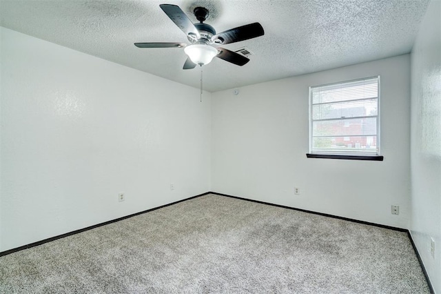 carpeted spare room featuring a ceiling fan, baseboards, visible vents, and a textured ceiling