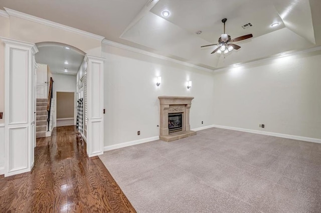 unfurnished living room with ceiling fan, decorative columns, visible vents, crown molding, and stairway