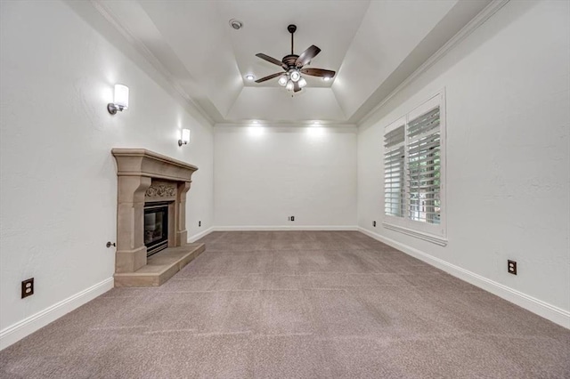 unfurnished living room with ceiling fan, a tile fireplace, lofted ceiling, ornamental molding, and carpet flooring