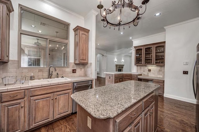 kitchen featuring backsplash, a sink, an inviting chandelier, ornamental molding, and dark wood-type flooring
