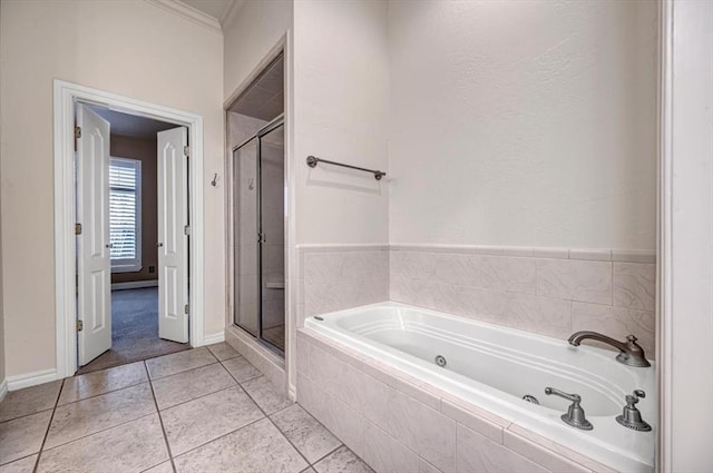 bathroom featuring a jetted tub, baseboards, tile patterned flooring, and a stall shower