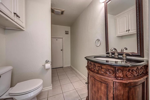 half bath with visible vents, tile patterned flooring, vanity, baseboards, and toilet