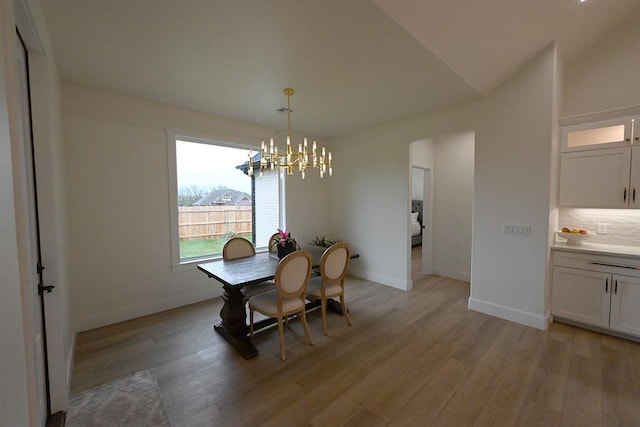 dining room featuring baseboards, a chandelier, and light wood-type flooring