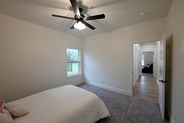 carpeted bedroom featuring baseboards and a ceiling fan