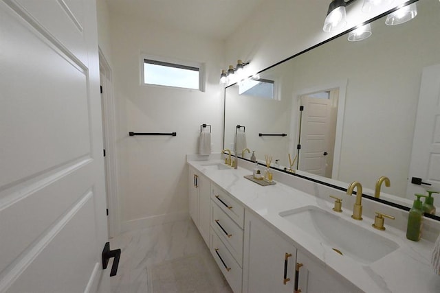 full bath with double vanity, a sink, and marble finish floor