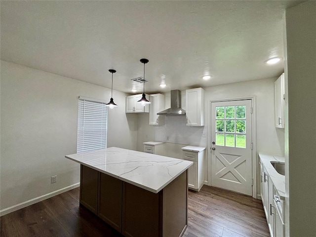 kitchen featuring visible vents, wall chimney exhaust hood, dark wood finished floors, and white cabinets