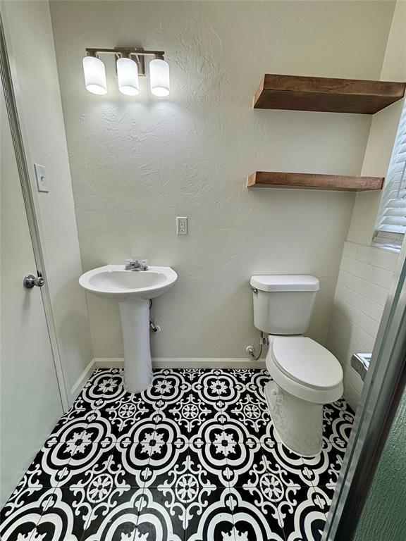 half bath featuring toilet and tile patterned flooring