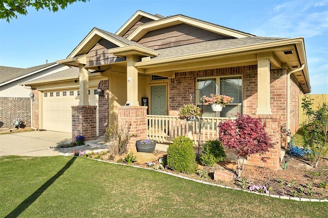 view of front of home featuring a shingled roof, an attached garage, brick siding, a front yard, and driveway