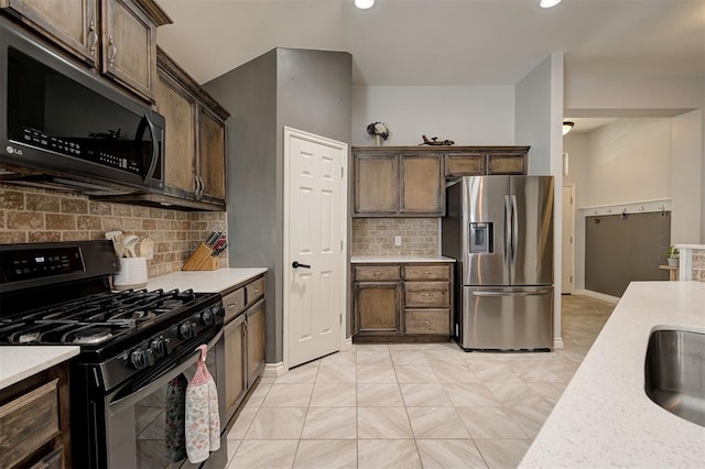 kitchen with dark brown cabinetry, gas range, stainless steel fridge, recessed lighting, and tasteful backsplash
