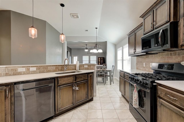 kitchen featuring backsplash, stainless steel appliances, a sink, and lofted ceiling