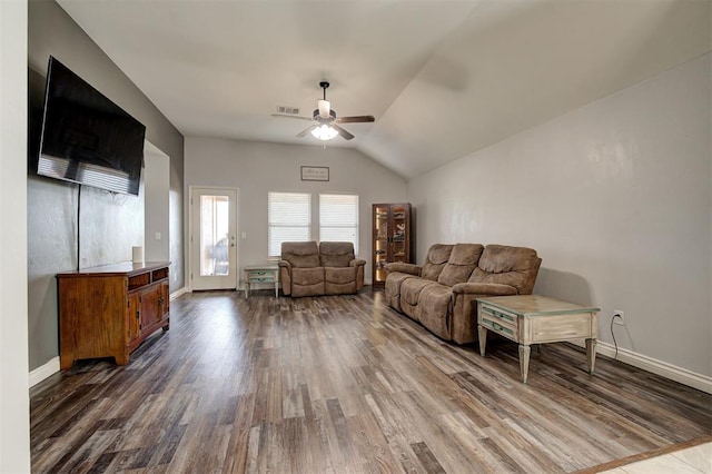 living area featuring visible vents, baseboards, a ceiling fan, dark wood finished floors, and vaulted ceiling