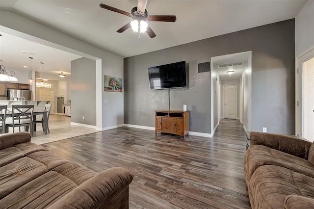 living area featuring baseboards, a ceiling fan, wood finished floors, and visible vents