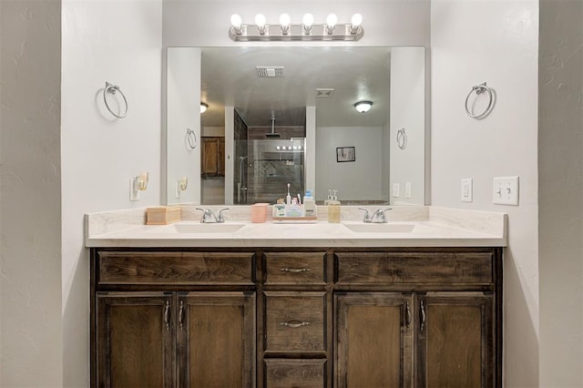 full bath with a sink, walk in shower, double vanity, and visible vents