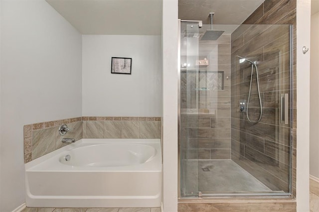 bathroom with a stall shower and a garden tub