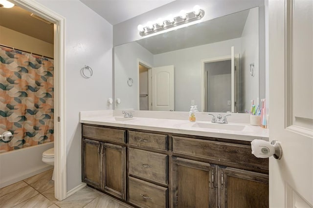 bathroom featuring double vanity, a sink, tile patterned floors, and toilet