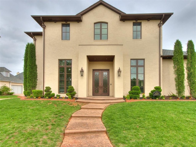 view of front of home featuring french doors, a front lawn, and stucco siding