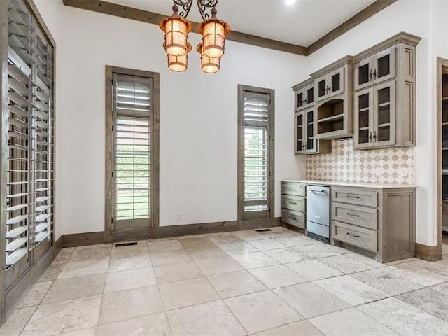 unfurnished dining area with baseboards, a chandelier, and visible vents