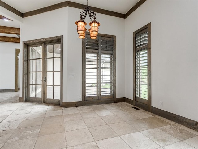 unfurnished dining area with an inviting chandelier, baseboards, crown molding, and french doors