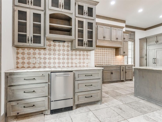 kitchen with light countertops, recessed lighting, decorative backsplash, paneled built in refrigerator, and glass insert cabinets